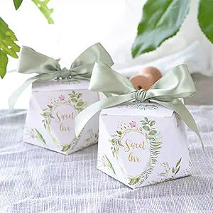 white gem shaped favor box with floral design and the words sweet love topped with a pale green bow